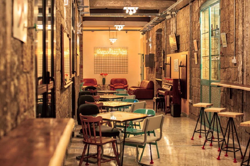 best hostels in naples, NeapolitanTrips Hostel common room with piano and marble floors