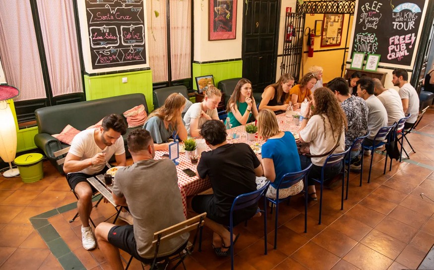 best hostels in seville, group of people eating together at Hostel One Centro