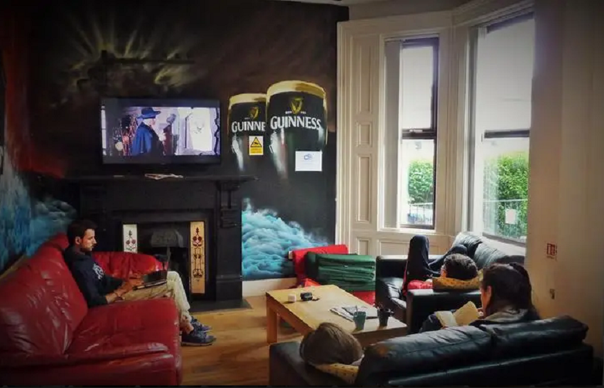 best hostels in belfast, people sitting in the lounge area on sofas at belfast city backpacker