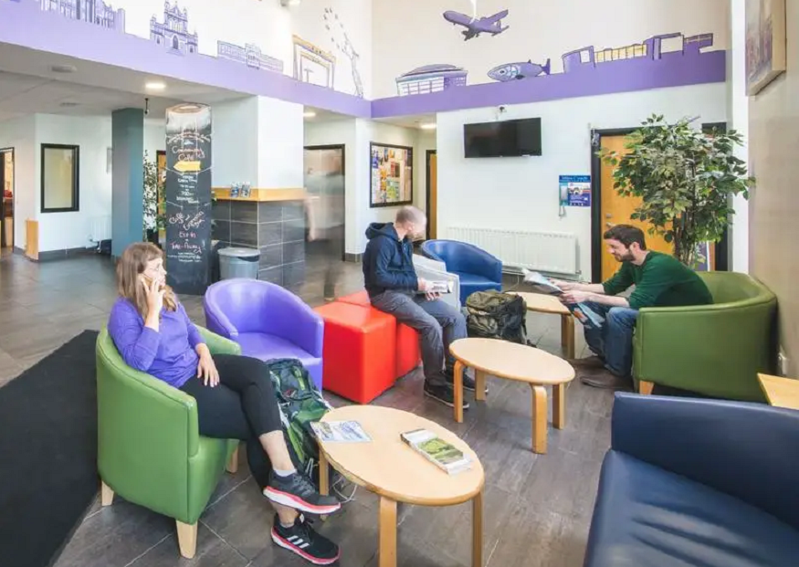 best hostels in belfast, people sitting in reception of Belfast International Youth Hostel