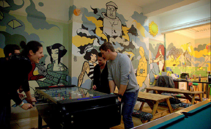 best hostels in belfast, people playing table football in global village hostel